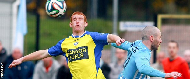 Bangor's Barry Walsh is challenged by Warrenpoint's Stephen Hughes