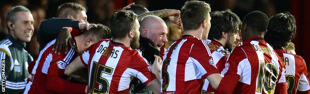 Andre Gray of Brentford celebrates scoring with team-mates and manager Mark Warburton