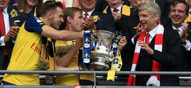 Aaron Ramsey (L) hands the FA Cup to Arsenal manager Arsene Wenger at Wembley