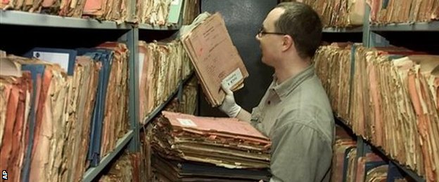 An unidentified official arranges files of the former East German Stasi secret service in Berlin, in 2002