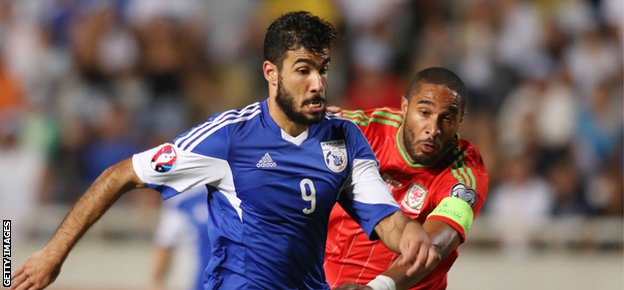 Cyprus' Nestor Mytidis (L) fights for the ball against Wales' Ashley Williams 